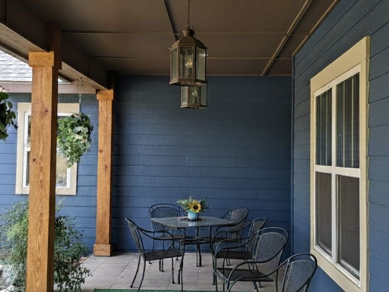 Covered porch with newly painted blue exterior walls