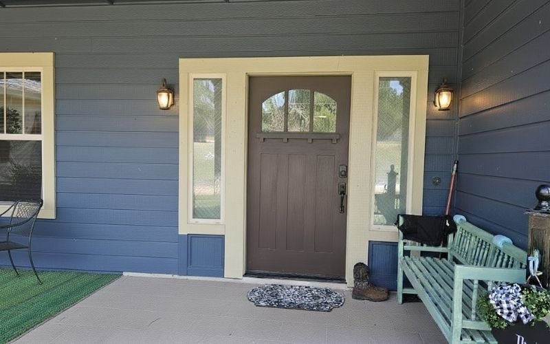 Front porch with freshly painted blue siding and entry door