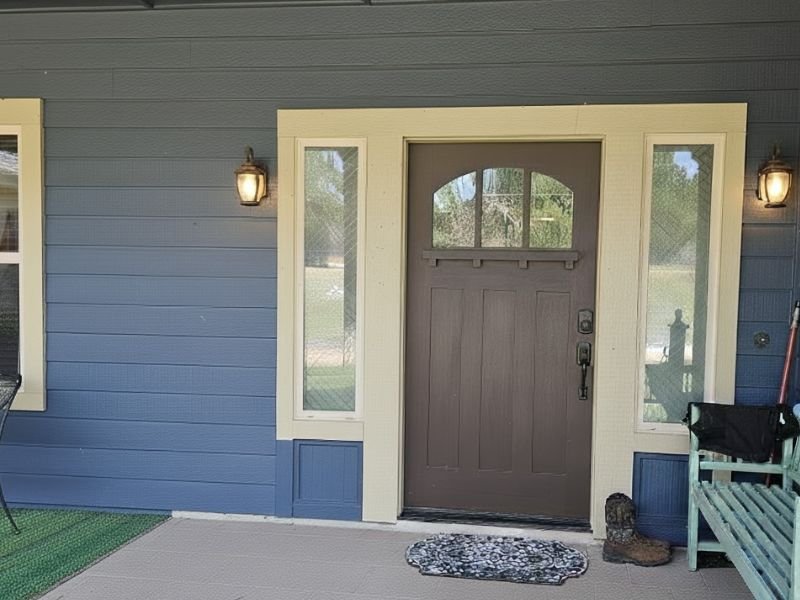Front porch with freshly painted blue siding and entry door